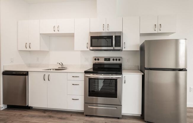 a white kitchen with stainless steel appliances and white cabinets