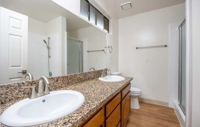 a bathroom with two sinks and a shower and a toilet