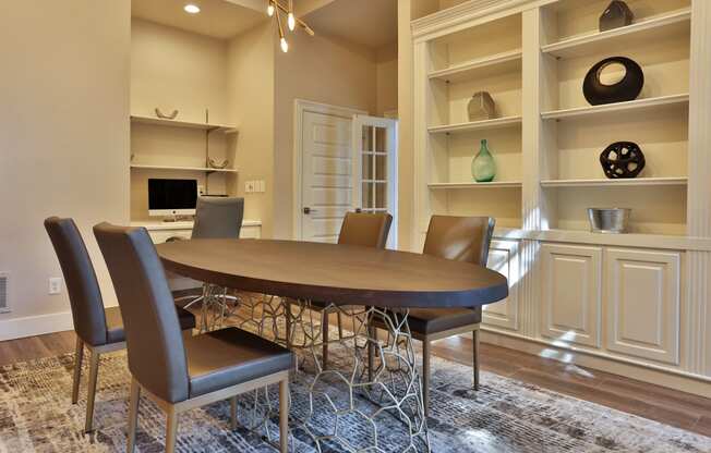 a dining room with a table and chairs in front of a bookshelf