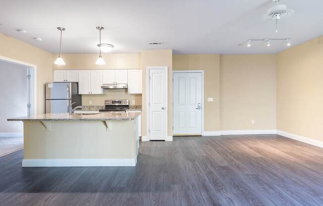 A kitchen with a refrigerator, sink, and cabinets.