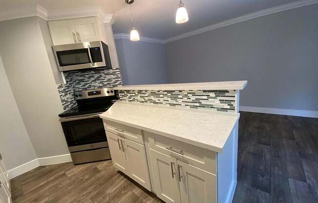 A kitchen with a white counter top and wooden cabinets.