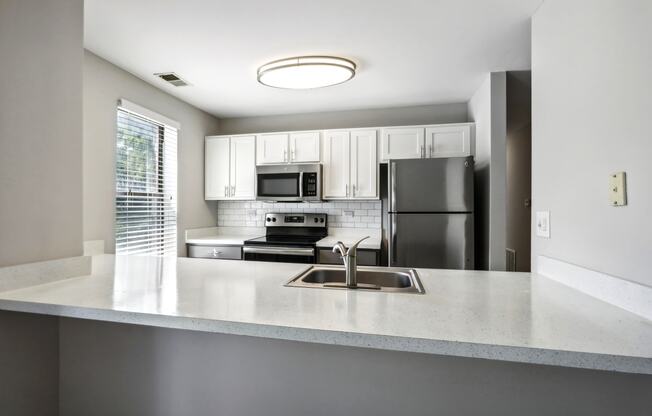 an empty kitchen with a sink and a refrigerator