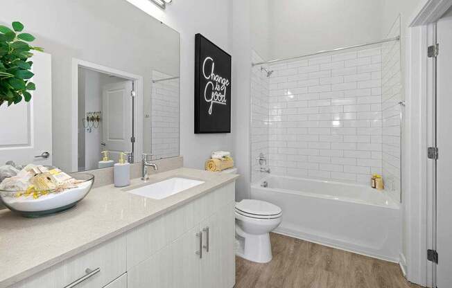 A bathroom with a white toilet and a white bathtub.