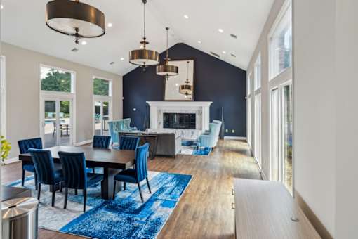 A modern dining room with a fireplace and blue chairs.