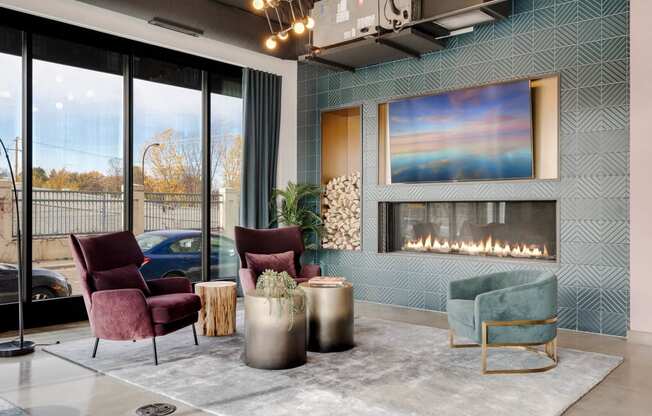 a living room with chairs and a fireplace