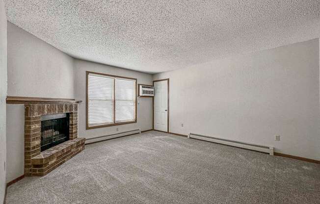 an empty living room with a fireplace and a window at Creekstone Falls, South Dakota, 57106
