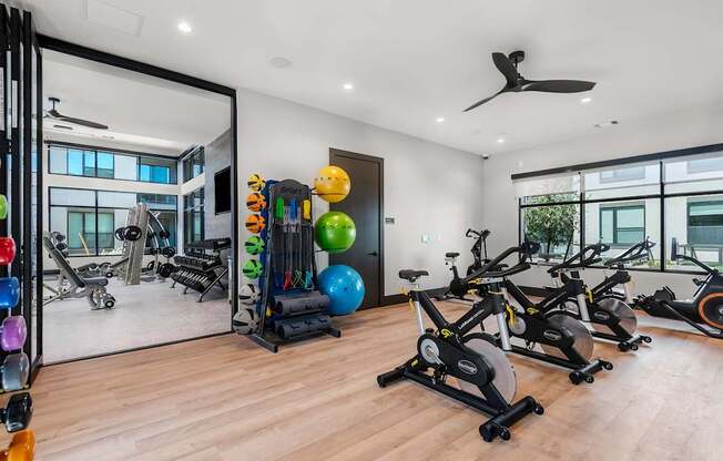 A spacious gym with a variety of exercise equipment and a mirror on the wall.