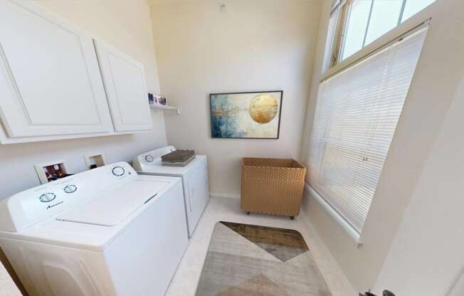 a laundry room with a washer and dryer and a window