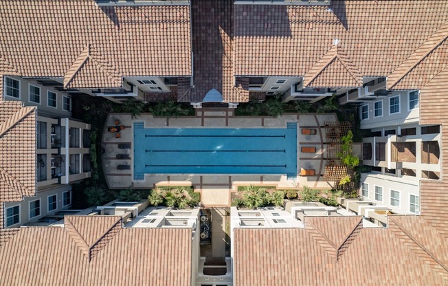 A blue rectangular object is in the middle of a courtyard surrounded by buildings.