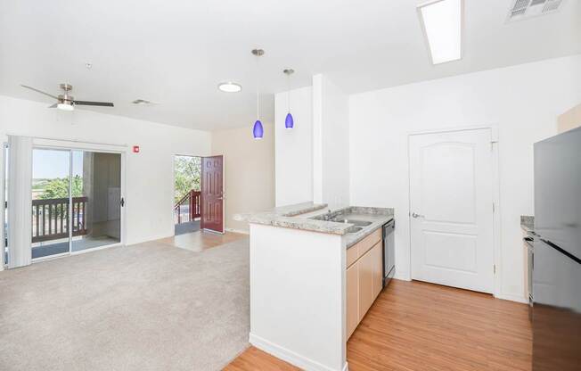 A kitchen with white cabinets and a wooden floor.