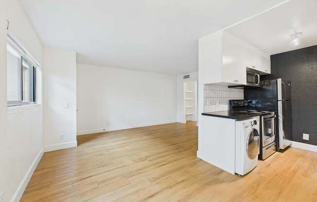 A kitchen with a black countertop and white appliances.