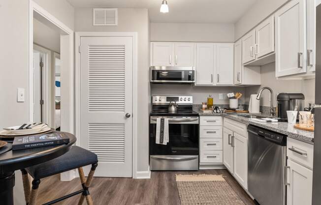 a kitchen with stainless steel appliances and white cabinets