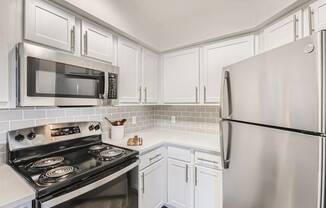 a kitchen with white cabinets and stainless steel appliances