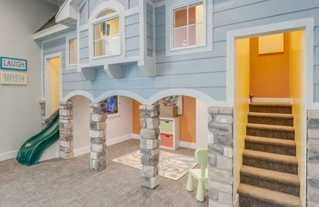 Playroom with 2 level playhouse with big slide and flat screen television
