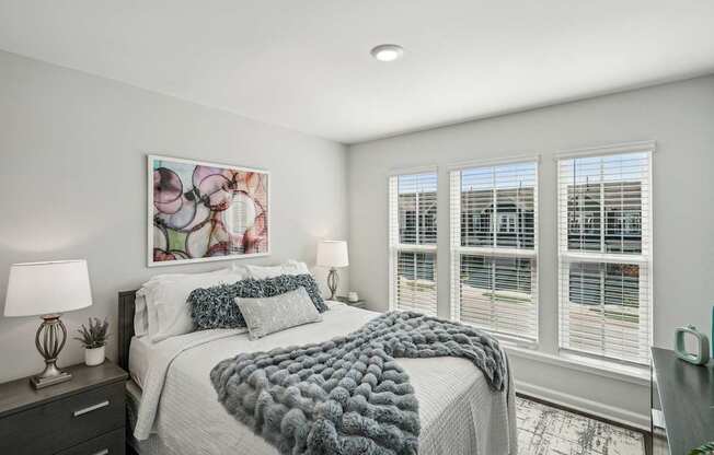 a bedroom with a bed and three windows