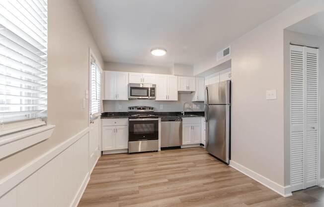 A kitchen with white cabinets and stainless steel appliances.