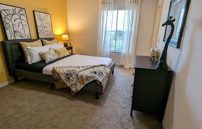 a bedroom with a bed and a dresser and a window