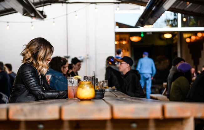 a woman sitting at a table in a bar with a drink