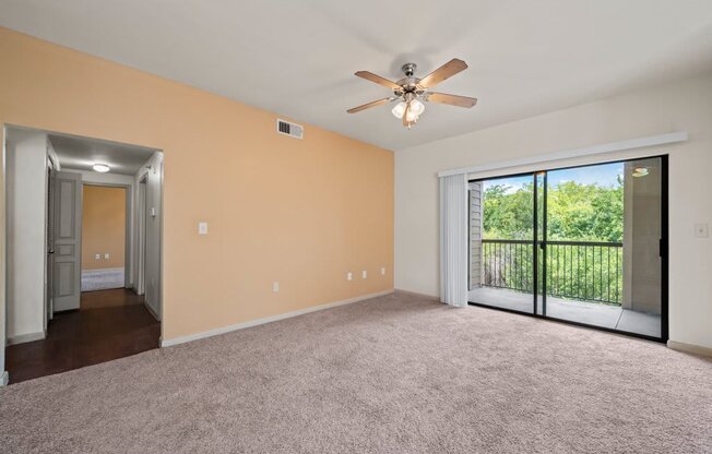 a living room with a ceiling fan and a sliding glass door