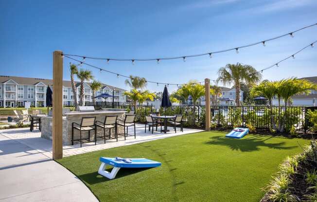 a yard with tables and chairs and a patio with grass