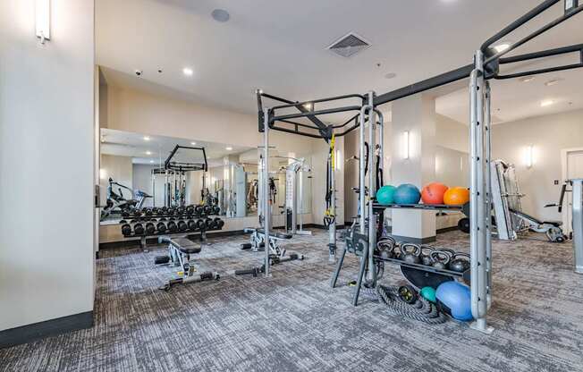 A gym with a variety of equipment including weights and weight machines.