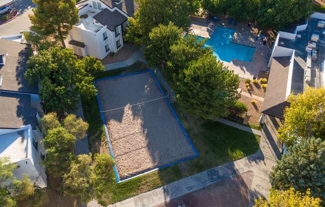 an aerial view of a neighborhood with a swimming pool and trees