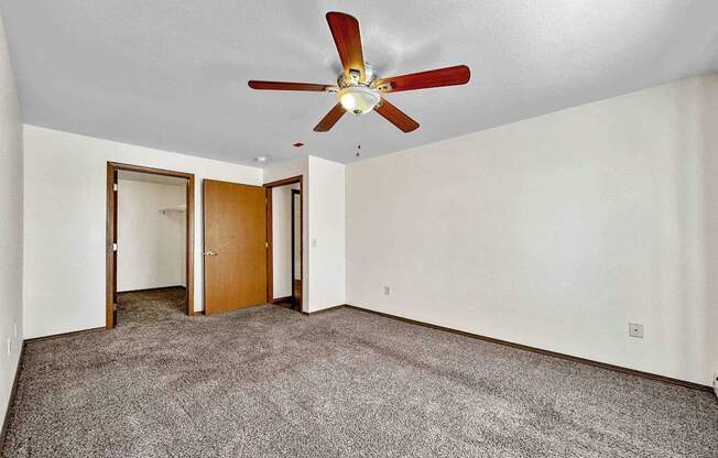 a living room with carpet and a ceiling fan