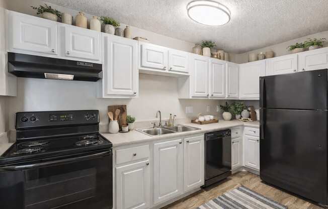 A black stove and oven in a kitchen with white cabinets.