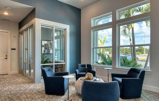 A room with blue chairs and a table with a bowl of food on it.