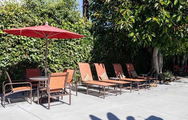 A row of chairs and a table are set up on a patio.