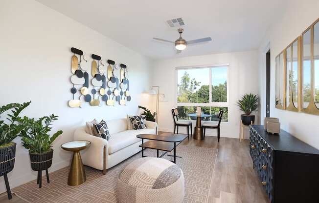 A living room with a white couch, a coffee table, and a large window.