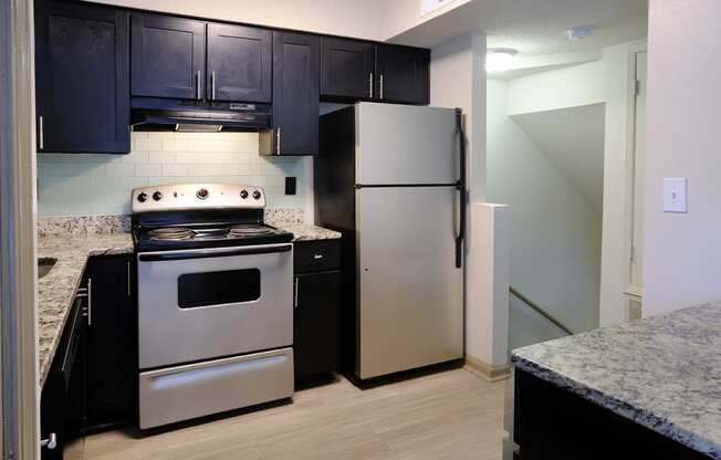 a kitchen with stainless steel appliances and black cabinets