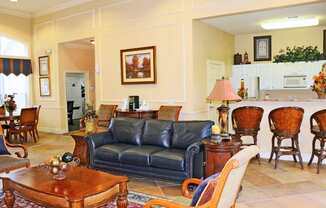 A living room with a blue couch and wooden furniture.