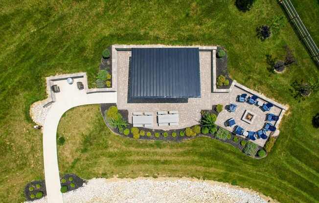 A house with a black roof is surrounded by a garden.