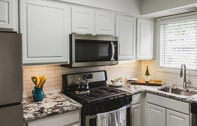 A modern white subway tile backsplash and matching white cabinets adorn our renovated homes