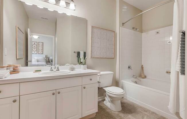 A white bathroom with a toilet, sink, and bathtub.