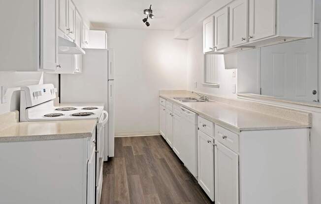 A kitchen with white appliances and cabinets.
