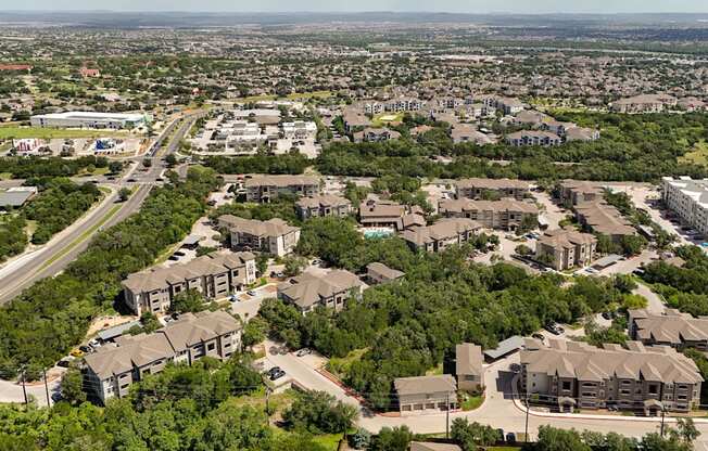 A bird's eye view of a residential area with multiple houses and a road.