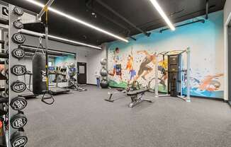 a large fitness room with a mural on the wall