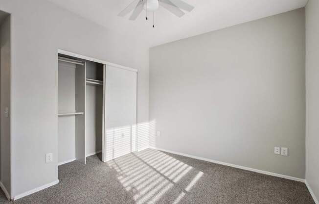 A room with a ceiling fan and a carpeted floor.