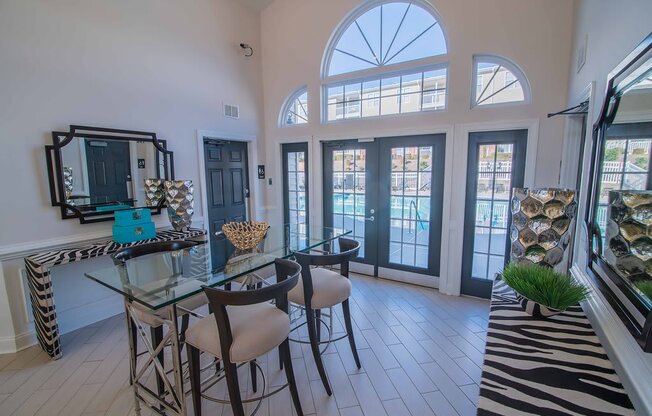A dining room with a glass table and chairs.