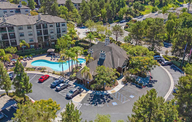 A large apartment complex with a pool and a parking lot.