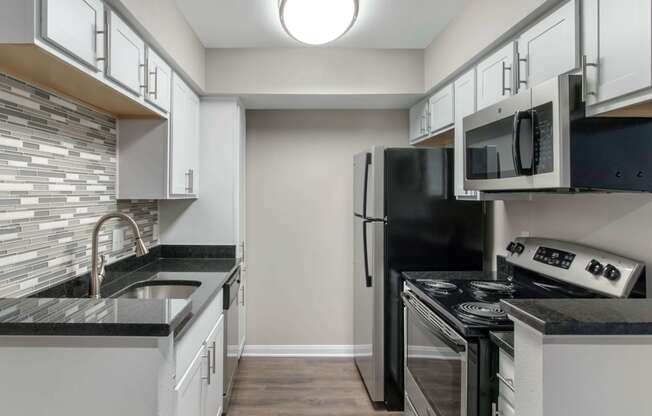 Kitchen with White Cabinets Black Counters and Stainless Steel Appliances