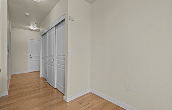 a bedroom with a door to a closet and a hard wood floor