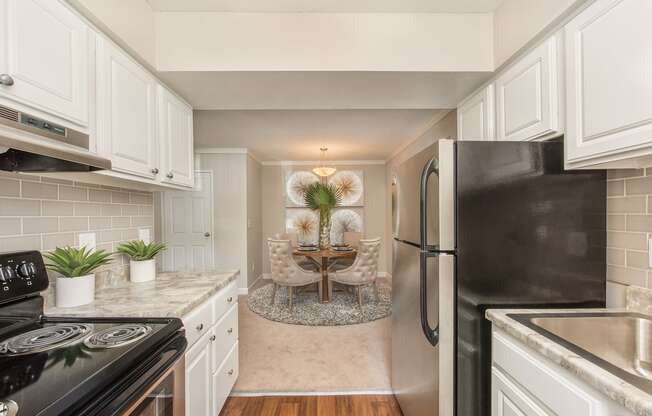 a kitchen with white cabinets and a dining room at Lodge of Overland Park Apartments, Overland Park , 66212