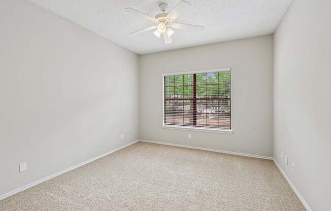 B2 bedroom with a ceiling fan and a window at Jefferson Place Apartments in Irving, TX