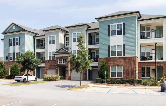 an apartment building with a white car parked in front of it