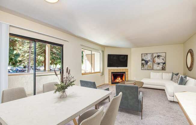 a living room with a white table and chairs and a fireplace