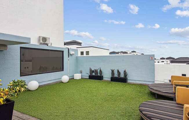 Sundeck with a television and seating at Twenty2 West luxury apartments in Miami, FL
