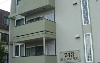 an apartment building with a car parked in front of it